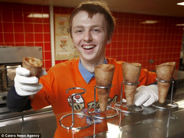 Dags Hofrats in an orange Pizza Cones shirt holding up freshly baked pizza cones